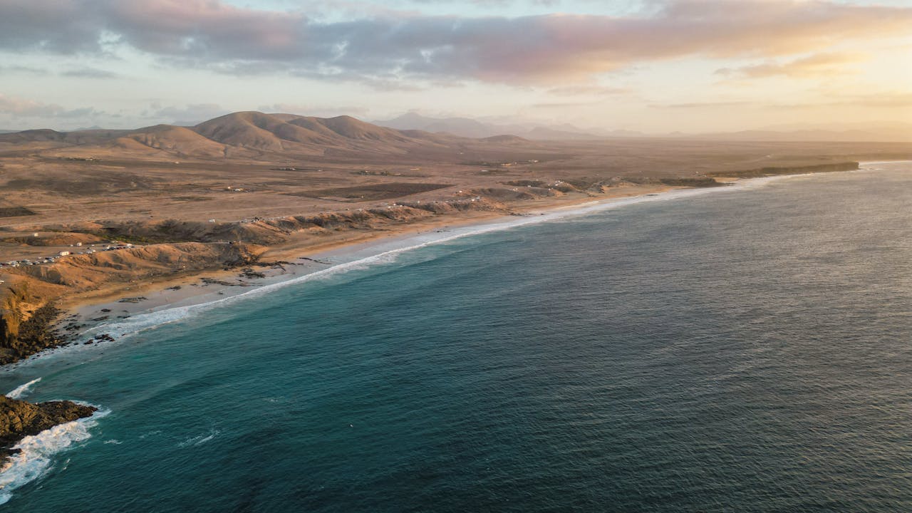Stunning aerial view of the Canary Islands coastline with mountains and ocean at sunset, Spain.